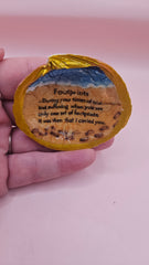 Handmade decorative shell with “Footprints” poem text, beach wave design, and golden painted rim, shown held in a hand.