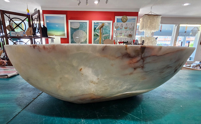 Large hand-carved onyx stone bowl with polished finish and creamy marbled tones in white, amber, and rose.