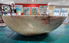 Large hand-carved onyx stone bowl with polished finish and creamy marbled tones in white, amber, and rose.