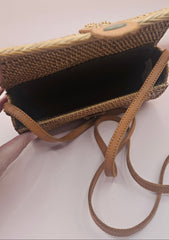 Handwoven rattan clutch with leather strap closure