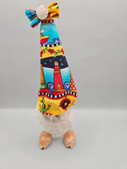 handcrafted seashell gnome with a colorful fabric hat and real seashells, perfect for coastal or beach-themed decor.