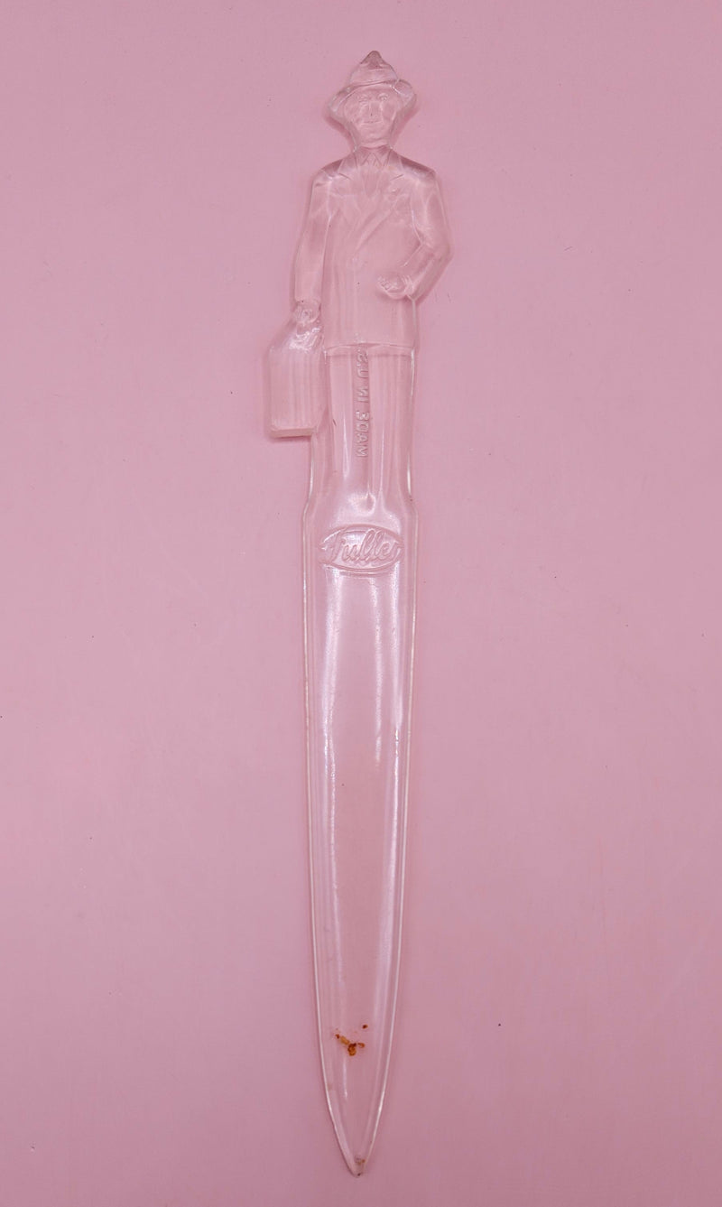Vintage clear plastic Fuller Brush Man letter opener, shaped like a businessman holding a briefcase, measuring 7.25 inches long.