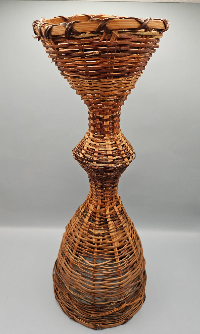 A 12.5" vintage woven wicker rattan vase basket with an hourglass shape, handcrafted from natural rattan, perfect for rustic or boho decor.