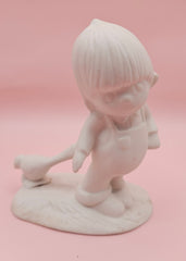 Unpainted ceramic bisque figurine of a boy in overalls with a bird, Precious Moments style