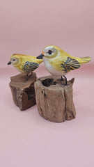 Hand-painted yellow bird figurine on wood stump with pink background – rustic handmade bird decor