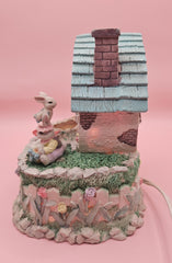 Vintage ABC Easter bunny cottage figurine with lighted house, animated bunnies, and music box that plays 