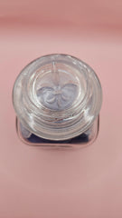 Vintage glass jar with cobalt and frosted sea glass, floral lid detail, ocean-inspired coastal decor on pink background
