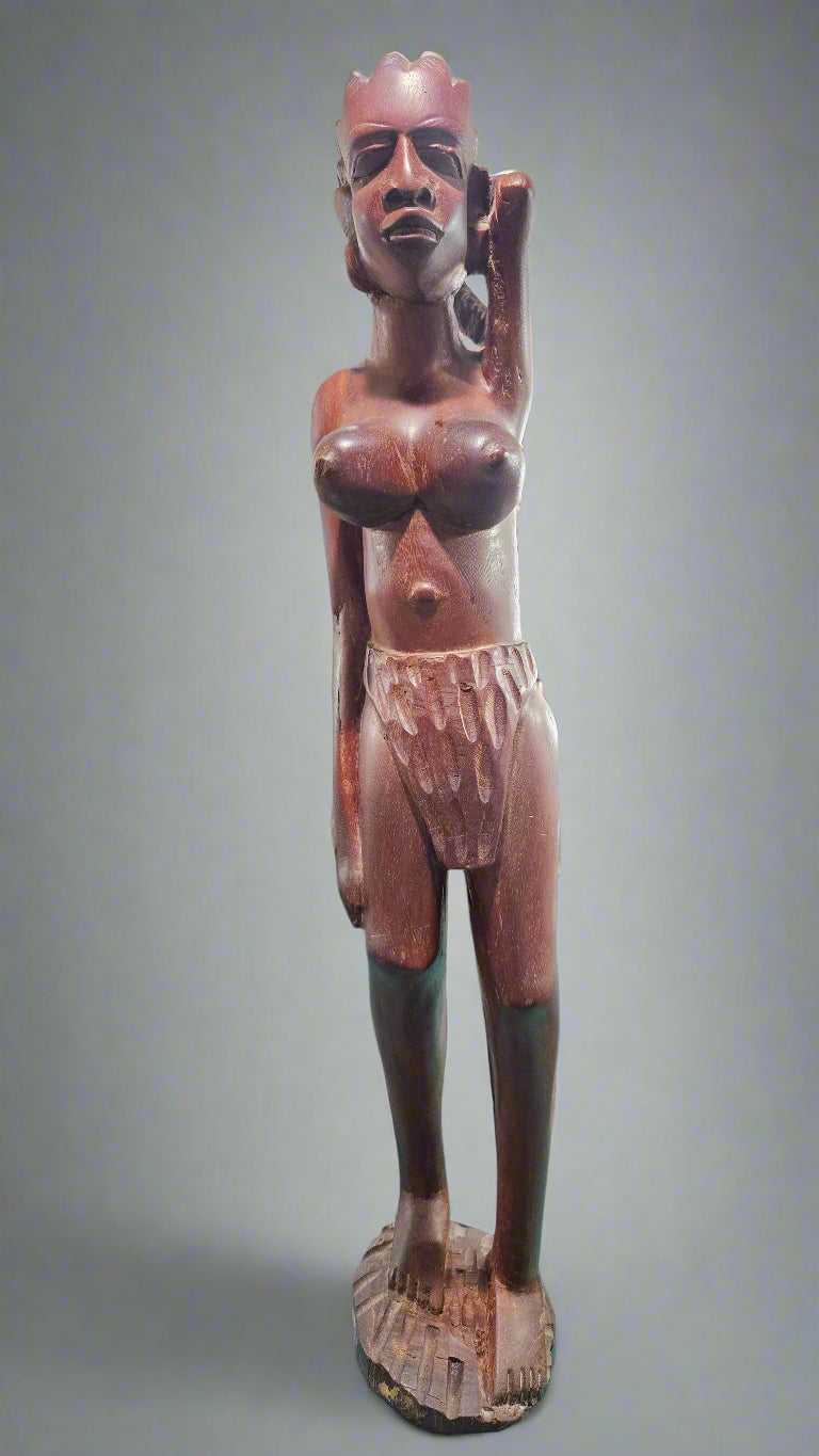 Vintage African tribal sculpture, solid wood, showcasing a tall figure with traditional attire and intricate carving.