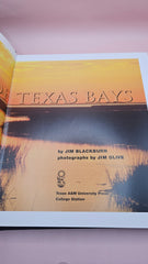 Spine of vintage hardcover book The Book of Texas Bays by Jim Blackburn, dark blue with gold text, published by Texas A&M University Press.