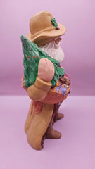 Hand-painted cowboy Santa figurine wearing a Western hat and coat, holding a toy sack and Christmas tree, measuring 9x6 inches, rustic holiday decoration.