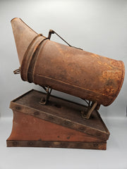 A vintage metal beekeeping smoker with a cone-shaped spout and rectangular body. The piece has a rustic, aged patina with visible rivets, making it a unique collectible or décor item for vintage and industrial-themed spaces