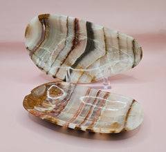 Oval onyx dish with bold natural stripes in tan, cream, and rust on pink background