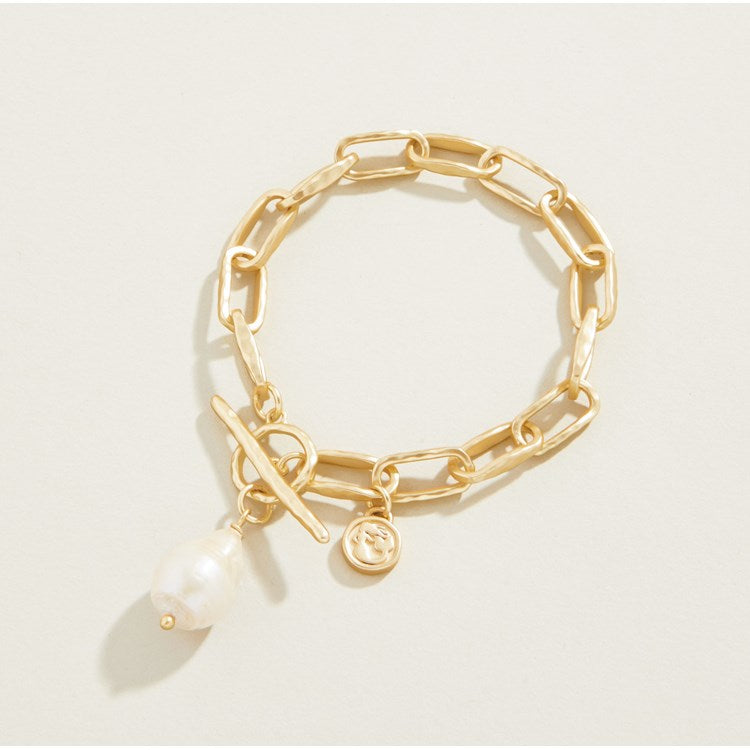 Gold toggle bracelet with a freshwater pearl charm and a signature Spartina mermaid charm on a matte gold-plated chain link design.