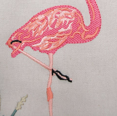 Close-up of the detailed flamingo embroidery on the Flamingo Placemat, showcasing vibrant pink and black stitching.