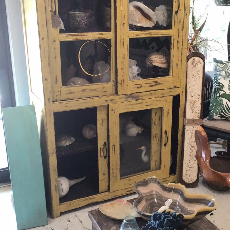 Rustic farmhouse style teak cabinet in bold yellow finish with patina